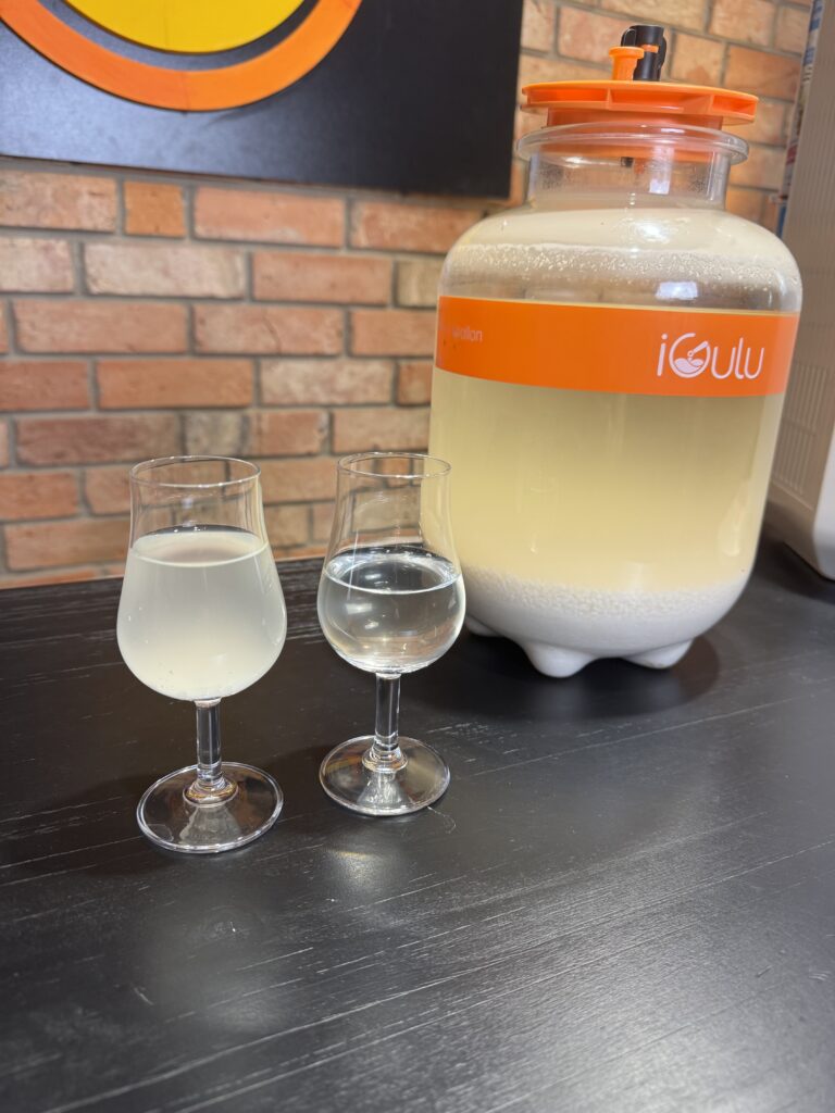 🍶 Sklarowane, krystalicznie przejrzyste, z bardzo delikatnymi nutami owocowymi i subtelną nutą ryżu w tle. Największe zaskoczenie? Przyjemnie długi, miękki, lekko kremowy finisz na języku. Jesteśmy naprawdę bardzo zadowoleni z efektu!
Dla celów edukacyjno-rozrywkowych zostawiliśmy też próbkę z dna osadu w stylu nigori - mleczne, kremowe, o subtelnie innym profilu smakowym. I to jest właśnie magia sake: jedna fermentacja, a dwa „style”, zależnie od stopnia sklarowania.